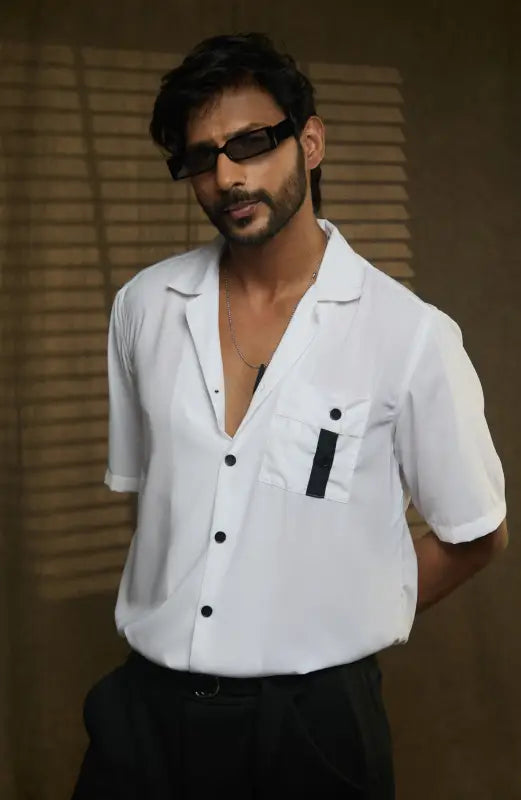 Person in white short-sleeved two button shirt with camp collar and sleek black pocket